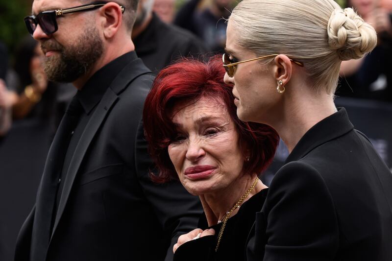 BIRMINGHAM, ENGLAND - JULY 30: (L-R) Jack Osbourne, Sharon Osbourne and Kelly Osbourne leave after viewing tributes to the late Ozzy Osbourne from fans as his funeral cortege travels through his home city of Birmingham on July 30, 2025 in Birmingham, England. The Black Sabbath frontman passed away on July 22nd at the age of 76. His death occurred just a little over two weeks after his final live performance at the 'Back to the Beginning' concert in his hometown of Birmingham. (Photo by Leon Neal/Getty Images)