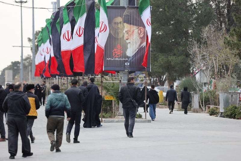 FILE PHOTO: People walk along a street with Iranian flags and a poster with images of Iran's late Supreme Leader Ayatollah Ali Khamenei, amid the U.S.-Israeli conflict with Iran, in Tehran, Iran, March 9, 2026. Majid Asgaripour/WANA (West Asia News Agency) via REUTERS ATTENTION EDITORS - THIS PICTURE WAS PROVIDED BY A THIRD PARTY/File Photo