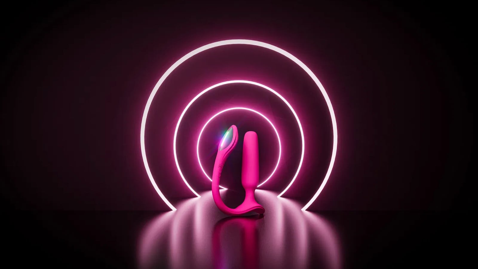 Pink wearable vibrator displayed against a dark background with glowing neon rings, highlighting its sleek modern design and flexible hands-free form.
