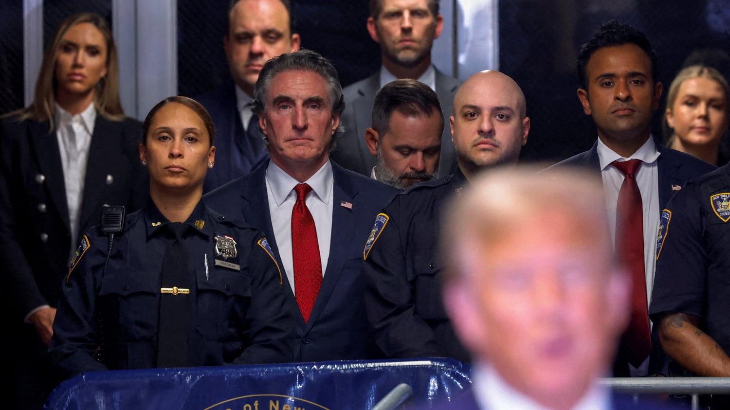 North Dakota Gov. Doug Burgum stands behind former President Donald Trump