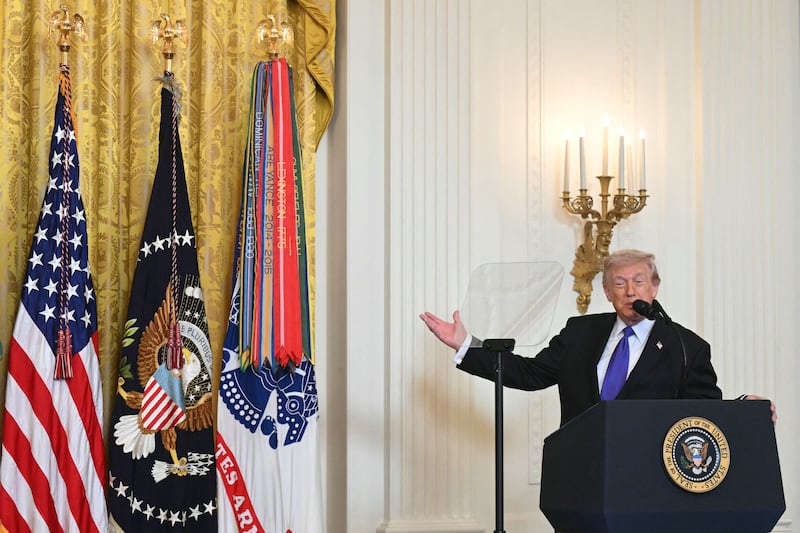 President Donald Trump gestures to the curtains behind which ballroom construction was taking place after becoming distracted while speaking during a Medal of Honor ceremony in the East Room of the White House on March 2, 2026.