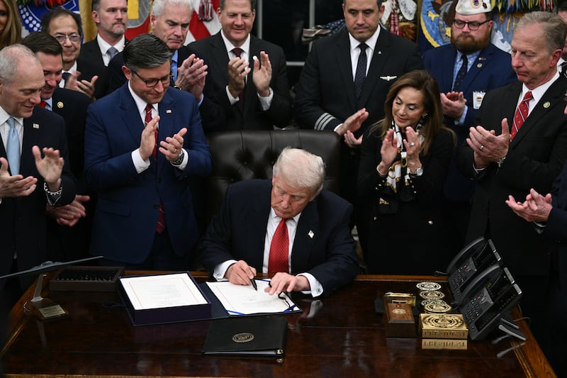 TOPSHOT - US President Donald Trump signs the bill package to re-open the federal government in the Oval Office of the White House in Washington, DC, on November 12, 2025. Congress on Wednesday ended the longest government shutdown in US history, 43 days that paralyzed Washington and left hundreds of thousands of workers unpaid while Republicans and Democrats played a high-stakes blame game. The Republican-led House of Representatives voted largely along party lines to approve a Senate-passed package that will reopen federal departments and agencies, as many Democrats fume over what they see as a capitulation by party leaders. (Photo by Brendan SMIALOWSKI / AFP) (Photo by BRENDAN SMIALOWSKI/AFP via Getty Images)