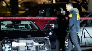 A damaged car is seen as law enforcement officials work the scene following reports that federal immigration officers shot and wounded people in Portland, Ore., Thursday, Jan. 8, 2026.