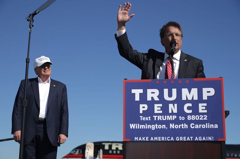 Republican presidential nominee Donald Trump (L) listens to North Carolina Governor Pat McCrory during a campaign rally at Wilmington International Airport November 5, 2016 in Wilmington, North Carolina.