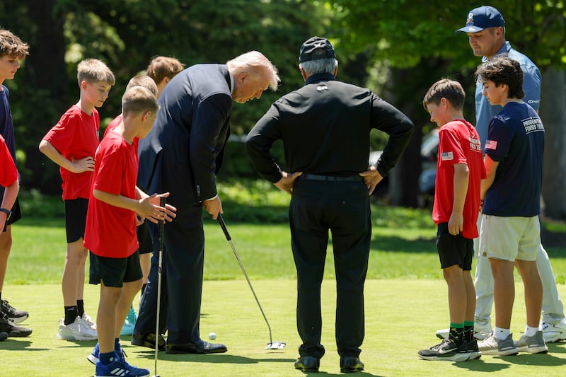 WASHINGTON, DC - MAY 05: U.S. President Donald Trump, professional golfer Bryson DeChambeau and retired professional golfer Gary Player golf with young athletes following a proclamation signing in the Oval Office of the White House on May 05, 2026 in Washington, DC. President Trump signed a presidential memorandum restoring the Presidential Fitness Test Award, which was reinstated by executive order in July 2025 and reintroduces a performance-based benchmark in physical education. (Photo by Anna Moneymaker/Getty Images)