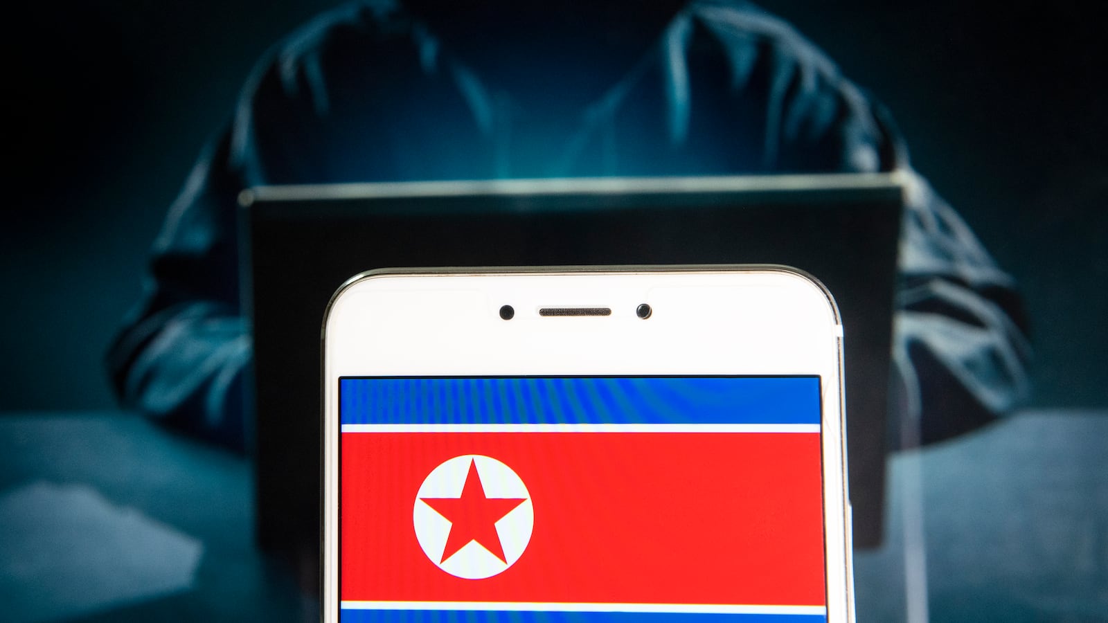 HONG KONG - 2019/04/05: In this photo illustration a democratic People's Republic of Korea, commonly known as North Korea flag is seen on an Android mobile device with a figure of hacker in the background. (Photo Illustration by Budrul Chukrut/SOPA Images/LightRocket via Getty Images)