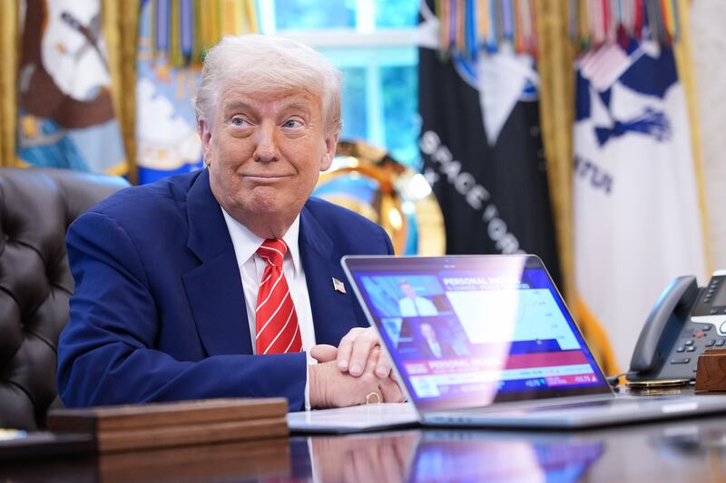 President Donald Trump plays a news video on a laptop in the Oval Office of the White House on May 30, 2025 in Washington, D.C.