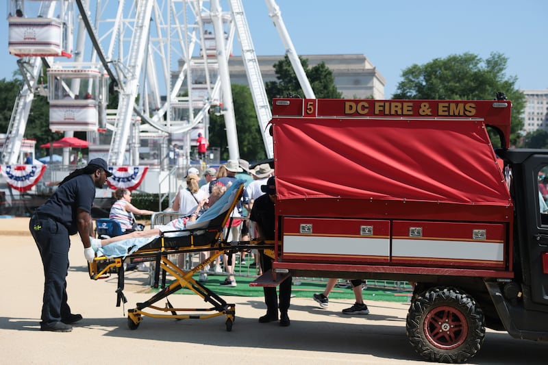 A woman is treated by DC Fire and EMS after collapsing while standing in line for the Ferris Wheel during the Great American State Fair on the National Mall on July 03, 2026, in Washington, DC. Many Fourth of July festivities have been shortened and some are facing cancellations amid an extreme, multi-day heat wave bringing dangerous triple digit temperatures to much of the eastern United States.