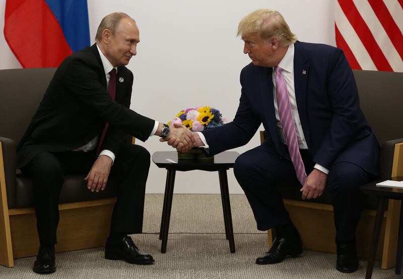 U.S. President Donald Trump (R) greets Russian President Vladimir Putin (L).