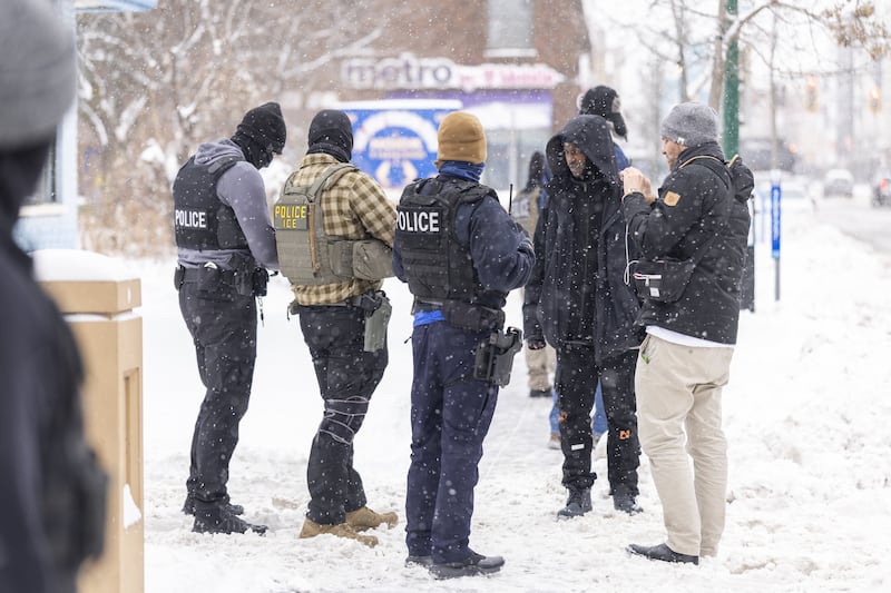 Immigrations, Customs, and Enforcement officers question a man's status on Lake Street near a Somali mall