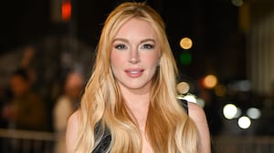 Lindsay Lohan, wearing her blonde hair in loose waves and a half-up hairstyle, attends the Our Little Secret screening at the Paris Theatre on November 18, 2024, in New York City.