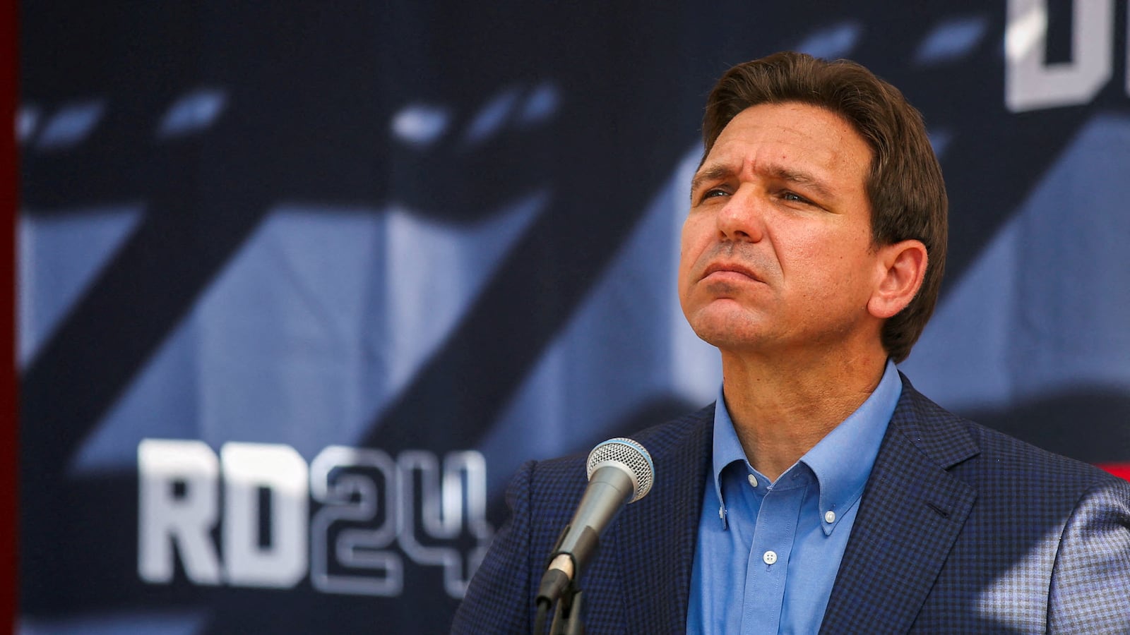 Ron DeSantis stares forward while speaking at a barbecue in New Hampshire.