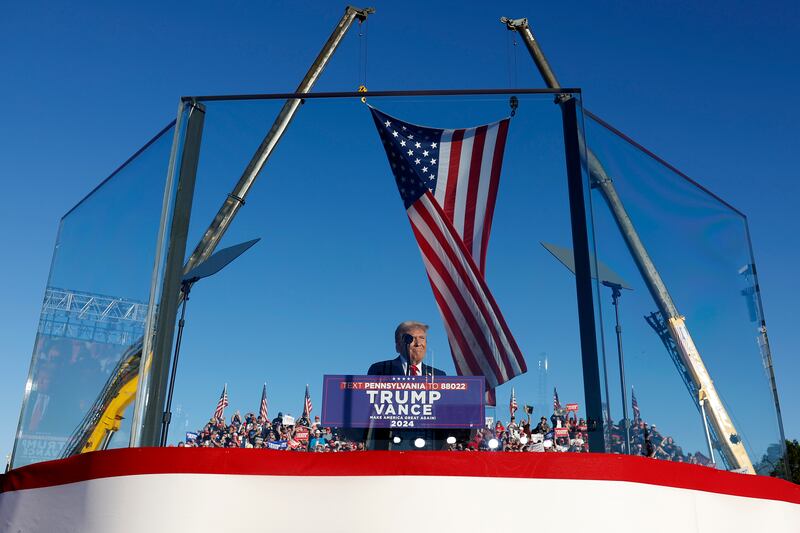 President Donald Trump addresses a campaign rally from behind bullet resistant glass at the Butler Farm Show fairgrounds on October 5, 2024. This is the first time that Trump has returned to Butler since he was injured during an attempted assassination on July 13.
