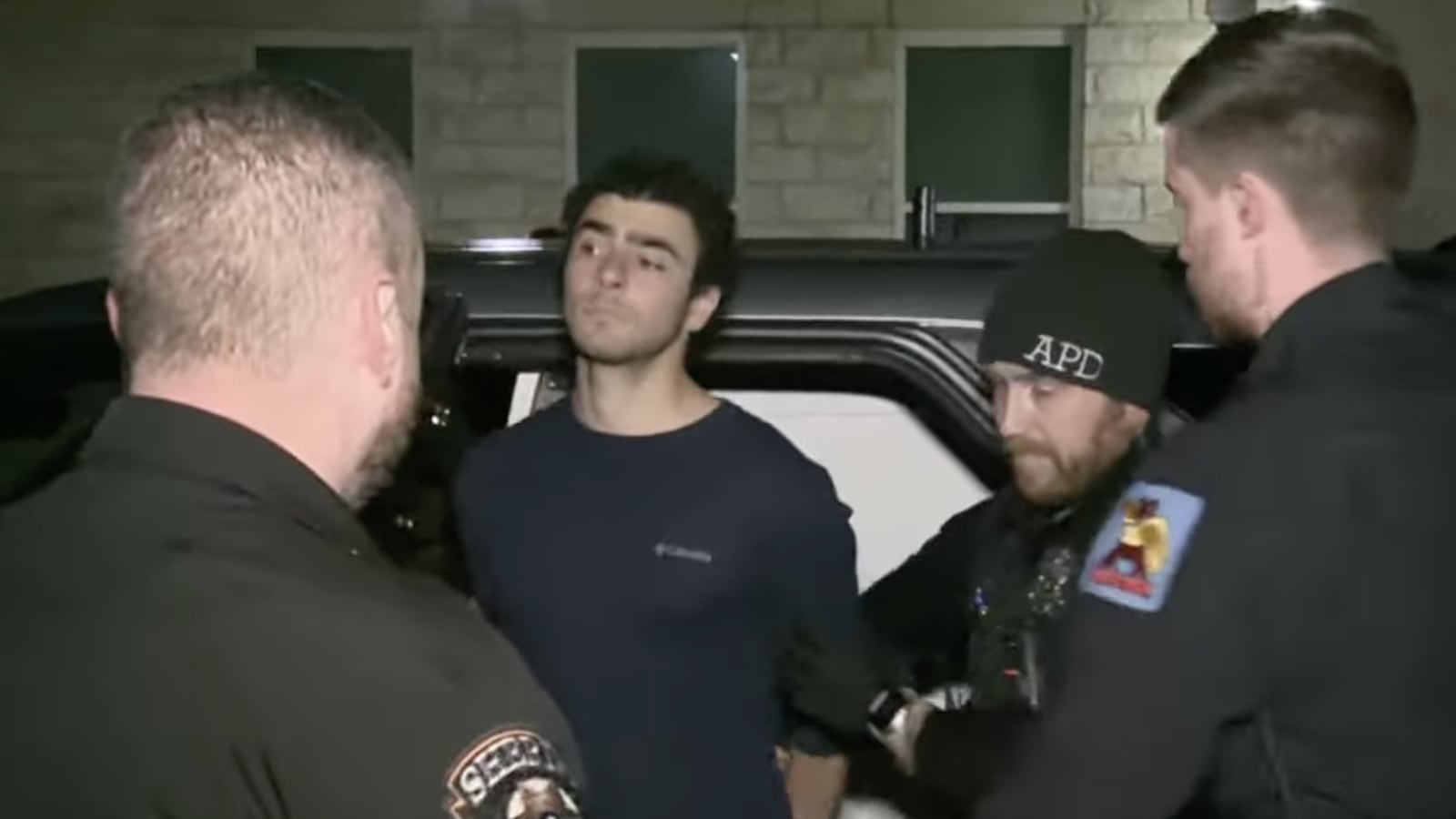 A man being escorted by police.