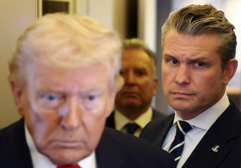 FILE PHOTO: U.S. President Donald Trump, with Secretary of Defense Pete Hegseth at his side, speaks to reporters aboard Air Force One on a flight from Dover, Delaware, to Miami, Florida, U.S., March 7, 2026. REUTERS/Kevin Lamarque/File Photo