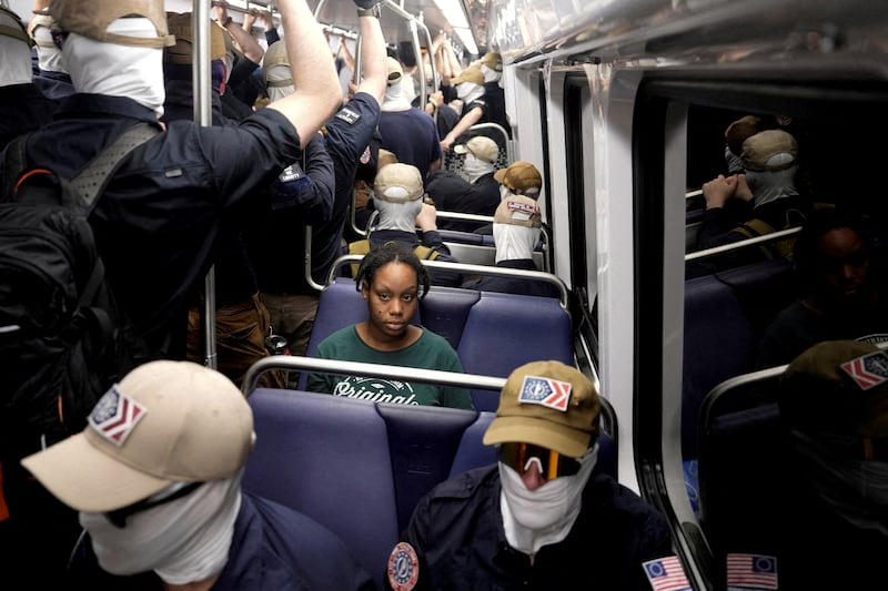 A commuter sits as members of the group Patriot Front ride the metro on the 250th anniversary of U.S. independence on the Fourth of July in Washington, D.C., U.S., July 4, 2026.