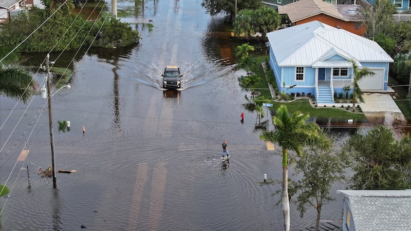 PUNTA GORDA - OCTOBER 10: In this aerial view, a person walks through flood waters that inundated a neighborhood after Hurricane Milton came ashore on October 10, 2024, in Punta Gorda, Florida. The storm made landfall as a Category 3 hurricane in the Siesta Key area of Florida, causing damage and flooding throughout Central Florida.