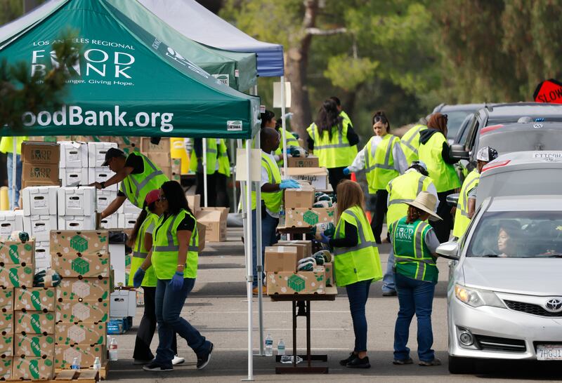Workers and volunteers help distribute food boxes to those in need at a large-scale drive-through food distribution, in response to the federal government shutdown and SNAP/CalFresh food benefits delays, on November 5, 2025 in City of Industry, California.