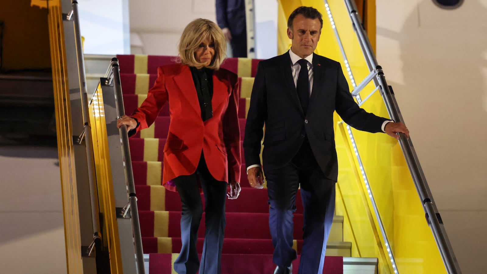 France's President Emmanuel Macron and his wife Brigitte Macron disembark from the plane upon their arrival at Noi Bai International Airport in Hanoi.
