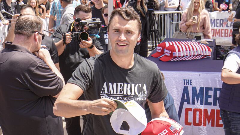SAN DIEGO, CALIFORNIA, UNITED STATES - 2025/05/01: Charlie Kirk, founder of Turning Point USA, throws hats to the public. Turning Point USA founder and American conservative political activist, Charlie Kirk sets up in UC San Diego's Town Square fielding rapid-fire questions from students and community members in a signature "change-my-mind"-style forum, while campus police and private security ring the perimeter to keep the busy plaza orderly. (Photo by Michael Ho Wai Lee/SOPA Images/LightRocket via Getty Images)