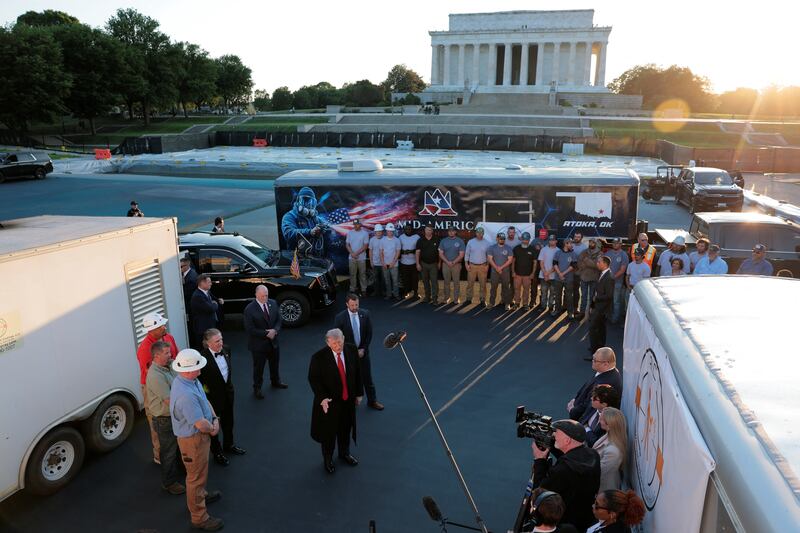onald Trump speaks to reporters next to Markwayne Mullin and oug Burgum during a visit to the Lincoln Memorial Reflecting Pool