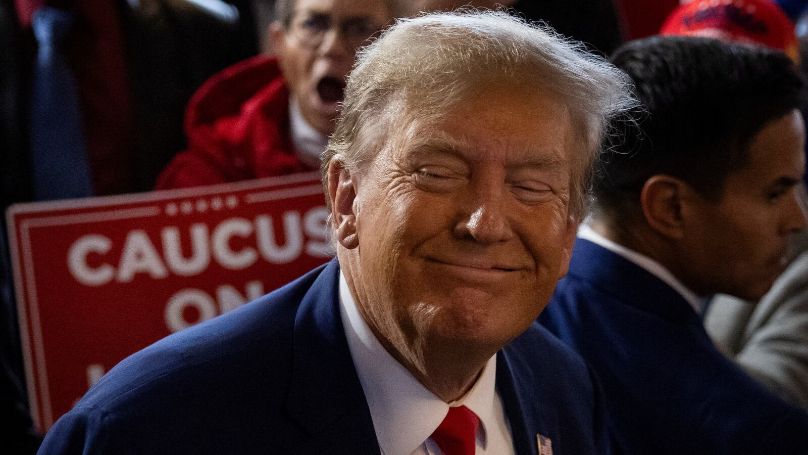 Donald Trump smiles with his eyes closed at an Iowa campaign event.