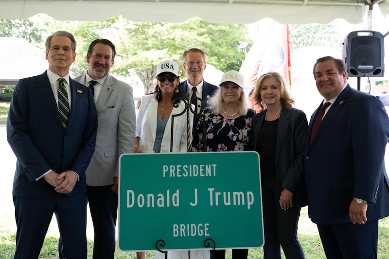 The president’s lone living sibling, wearing a white USA hat and a dark blue blouse, and his brother’s widow, wearing a white coat, turned up for Thursday’s event.
