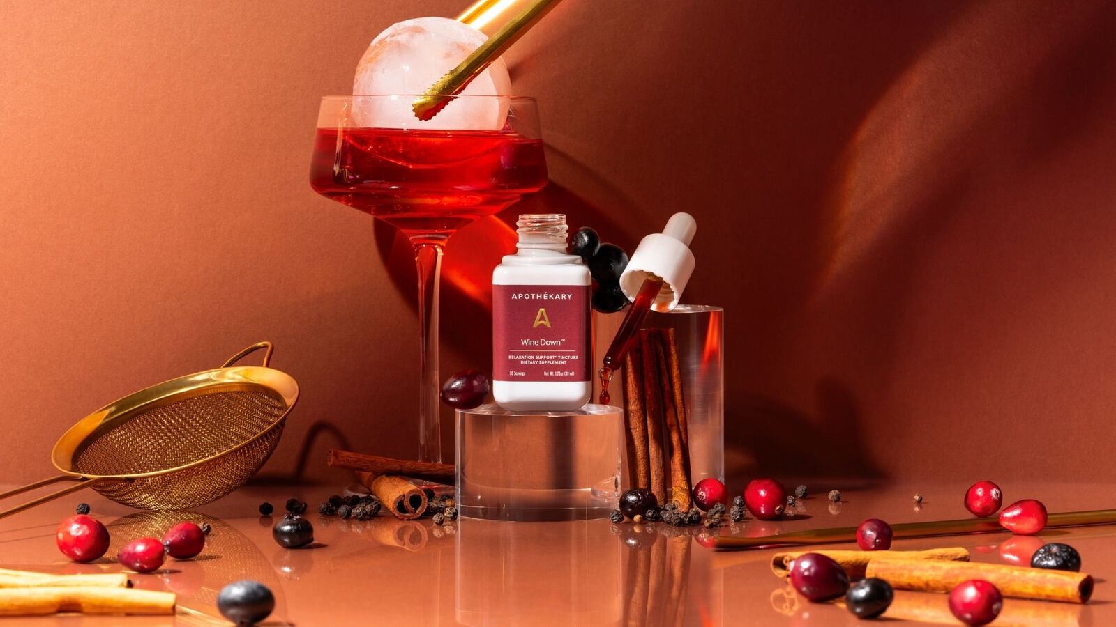 Wine Down™ by Apothékary drink with next to a glass of red wine and ingredients