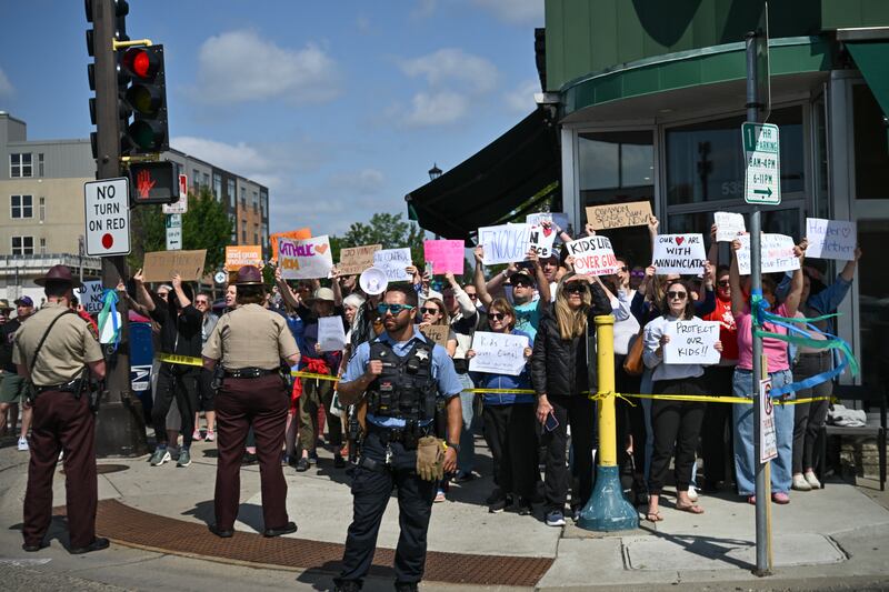 People protest as Vice President JD Vance and Second Lady Usha Vance arrive to pay their respects to victims of the Annunciation Catholic Church shooting in Minneapolis