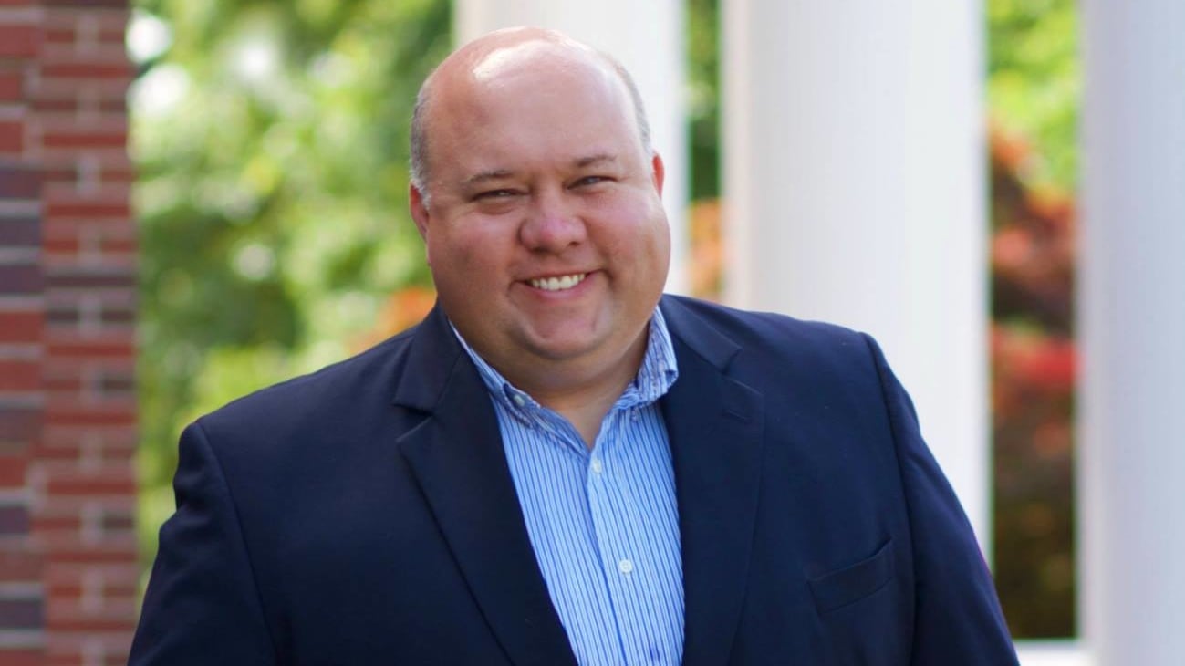 Bubba Copeland, wearing a button-up shirt and blazer, smiles in a headshot.