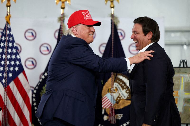 U.S. President Donald Trump shares a moment with Florida Governor Ron DeSantis after touring a temporary migrant detention center informally known as "Alligator Alcatraz" in Ochopee, Florida, U.S., July 1, 2025.