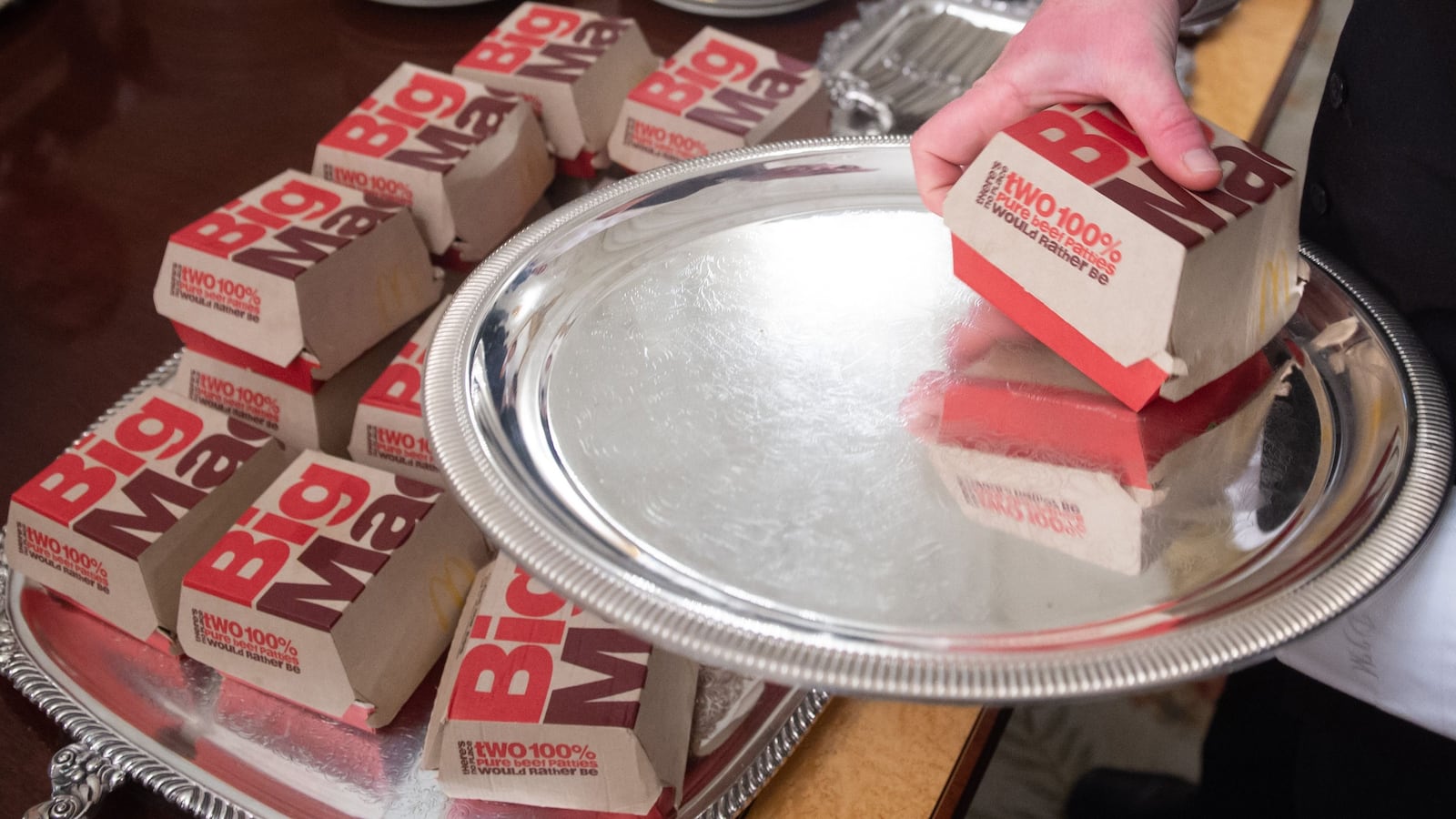 A White House usher plates Big Macs from McDonalds, some of the fast food the US president purchased for a ceremony honoring the 2018 College Football Playoff National Champion Clemson Tigers in the State Dining Room of the White House in Washington, DC, January 14, 2019. - US President Donald Trump says the White House chefs are furloughed due to the partial government shutdown. (Photo by SAUL LOEB / AFP) (Photo credit should read SAUL LOEB/AFP via Getty Images)