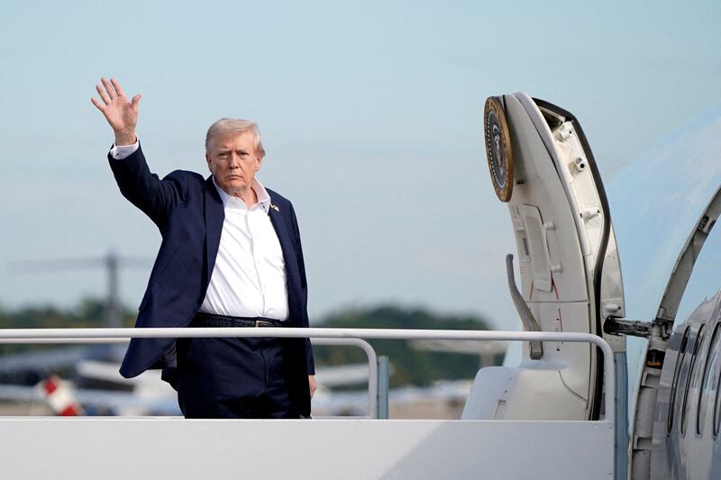President Donald Trump gestures as he boards Air Force One