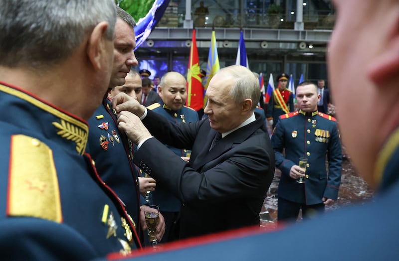 In this pool photograph distributed by the Russian state agency Sputnik, Russia's President Vladimir Putin presents Gold Star medals of Hero of Russia to service members after an expanded meeting of the Russian Defence Ministry Board at the National Defence Control Centre in Moscow on December 17, 2025. (Photo by Alexander KAZAKOV / POOL / AFP via Getty Images)