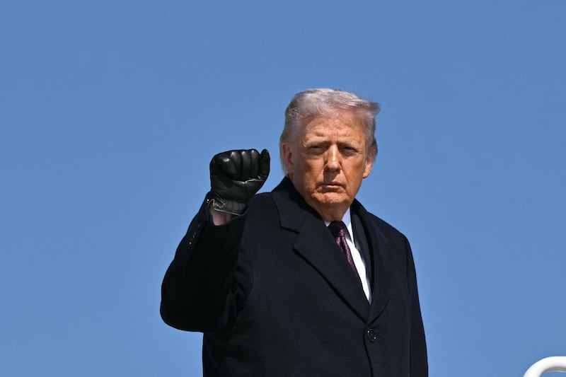 U.S. President Donald Trump pumps his fist as he boards Air Force One at Joint Base Andrews in Maryland before departing for Texas on February 27, 2026.