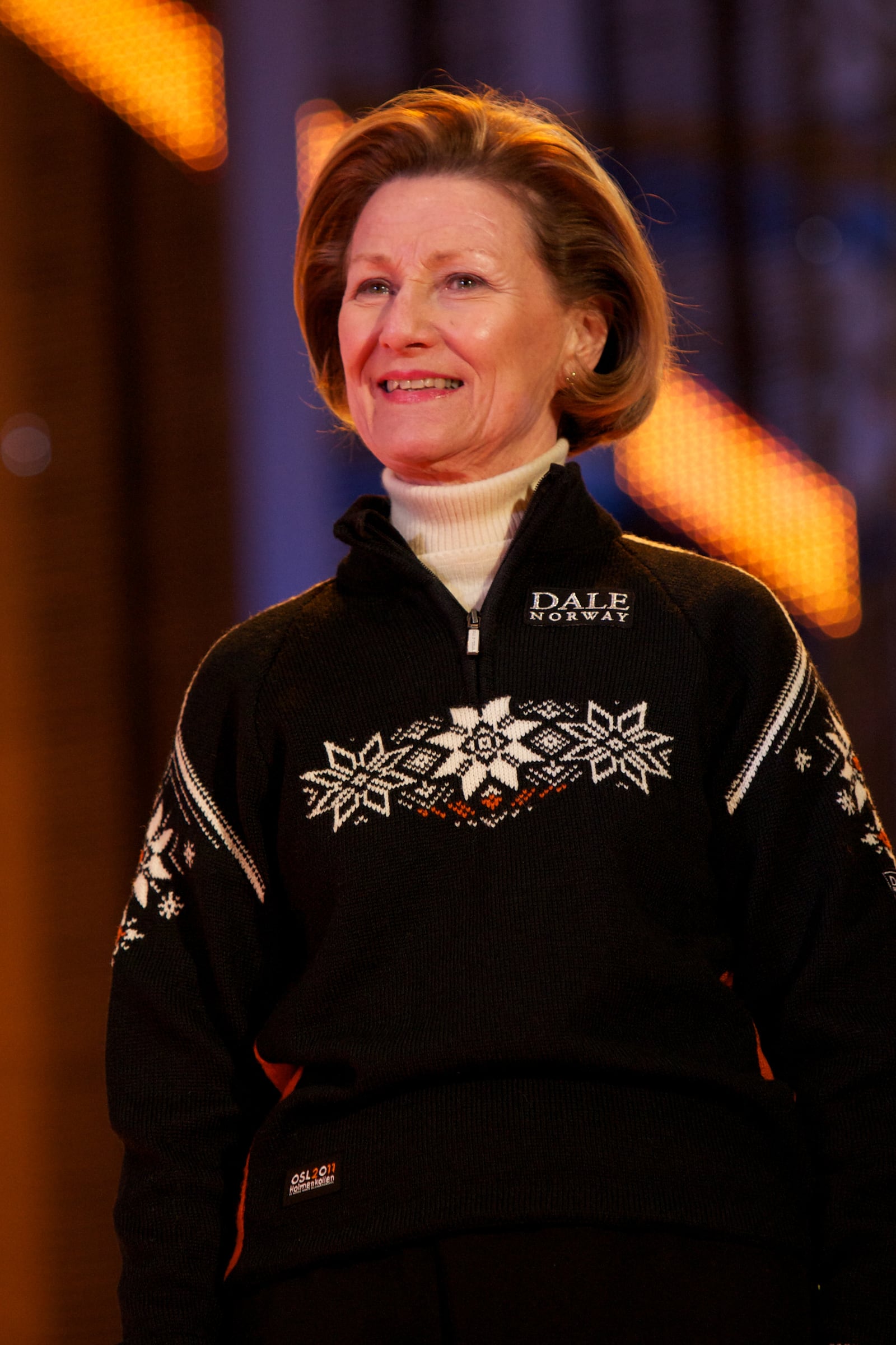 Queen Sonja of Norway at the Men's Large Hill Team medal ceremony at the FIS Nordic World Ski Championships in 2011, wearing a sweater with the Selburose print.