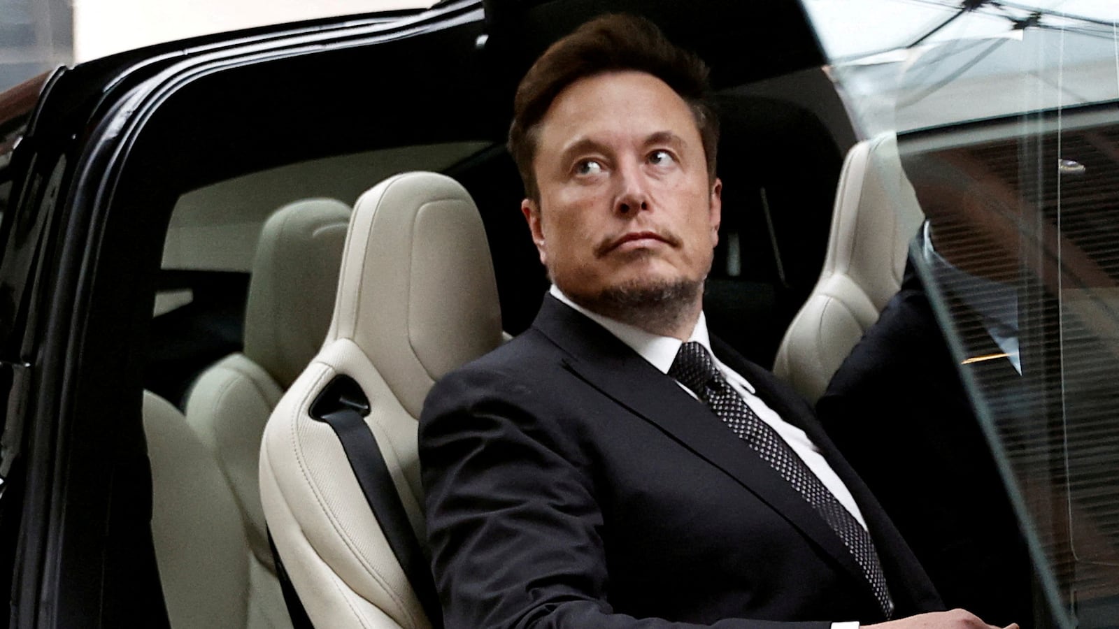 Elon Musk sits in a Tesla vehicle in Beijing.