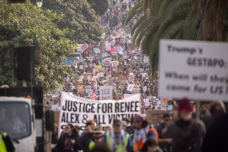 A long stream of protestors holding signs on a street in San Francisco.