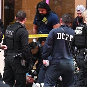 Members of the U.S. Secret Service tend to a wounded man on the scene of a shooting near the White House on May 23, 2026 in Washington, DC. Emergency teams work the scene after multiple rapid-fire gunshots ring out outside the White House.