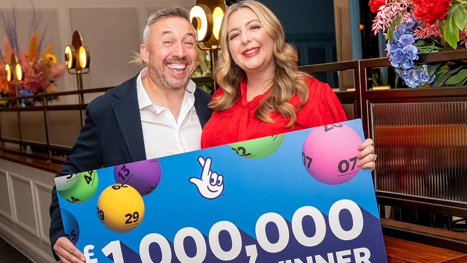 Couple holding sign saying 1,000,000 winner