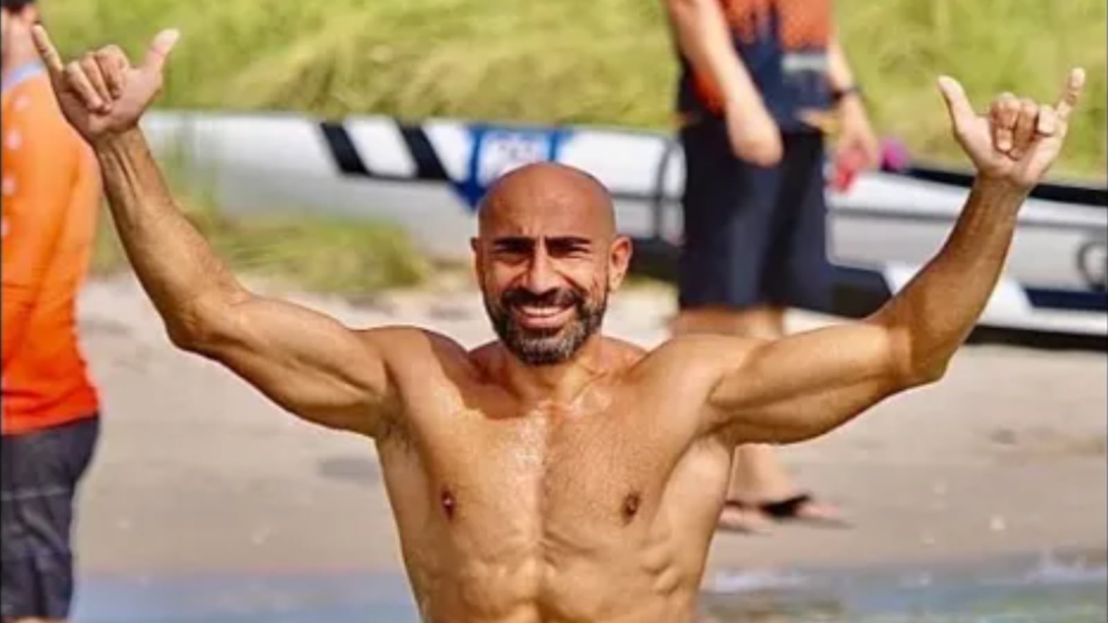 Eiffel Gilyana gives the “hang loose” sign with both hands as he smiles shirtless.