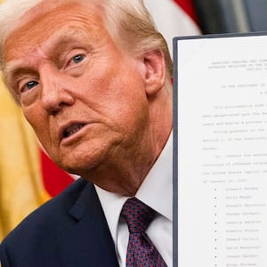 Donald Trump holding up an executive order.