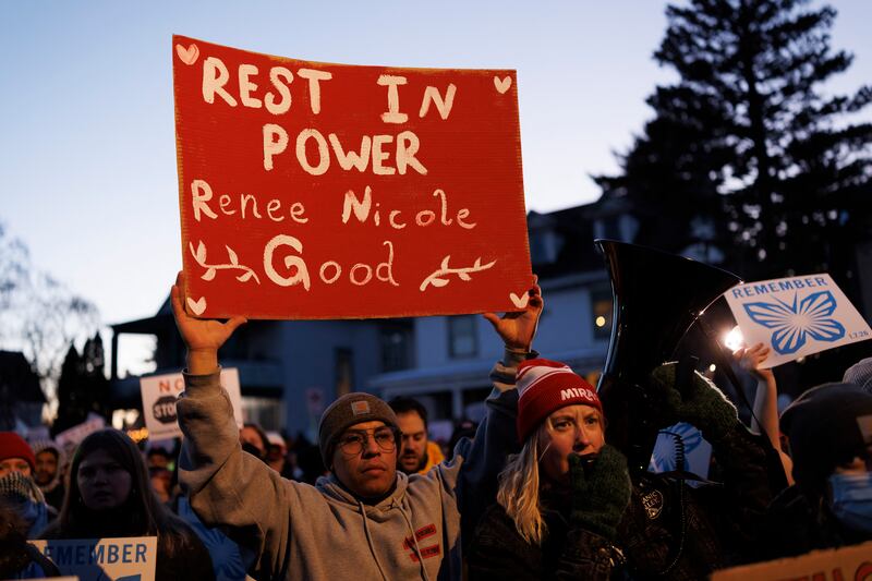 People attend a vigil at the site where a woman was shot and killed by an immigration officer