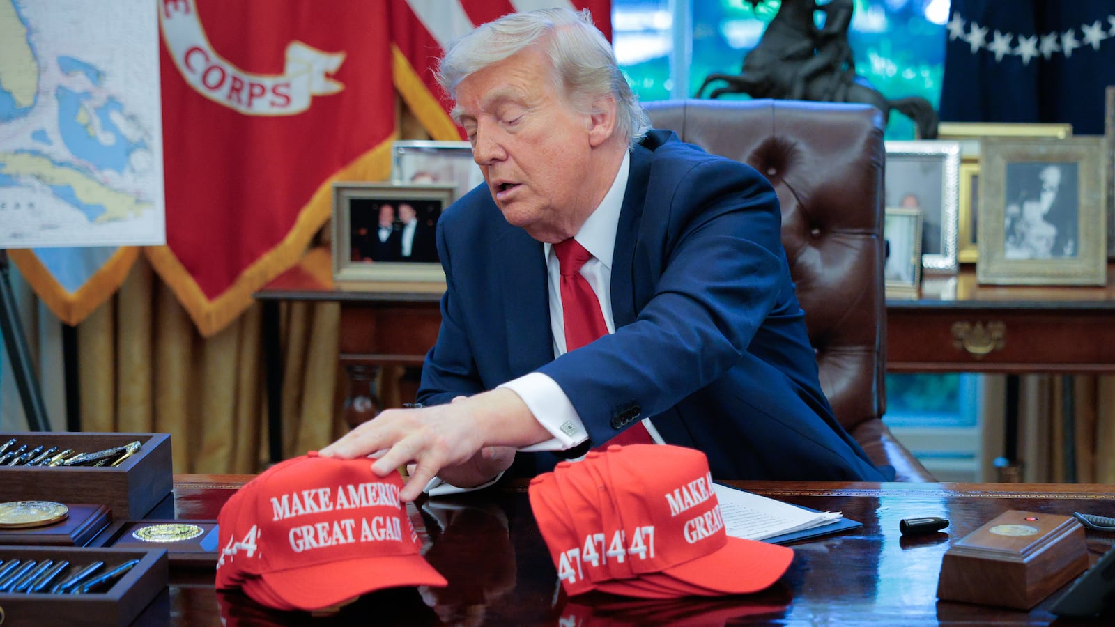 President Donald Trump adjusts "Make America Great Again" hats.