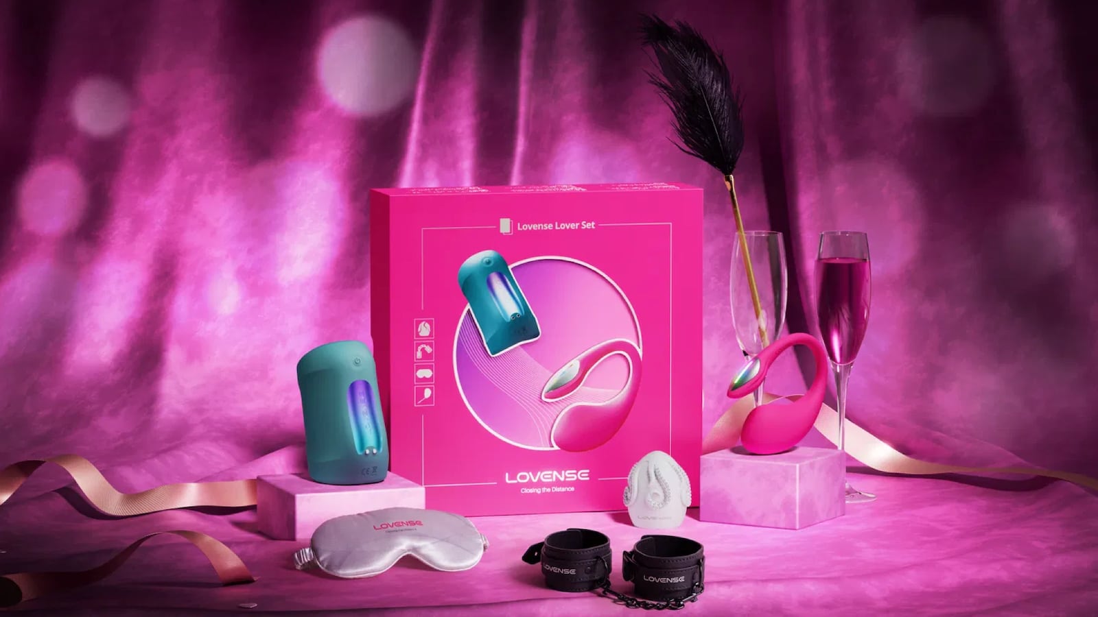 Lovense Lover Set displayed with toys and accessories including vibrator, massager, feather tickler, blindfold, and wrist cuffs in a romantic Valentine’s Day setting