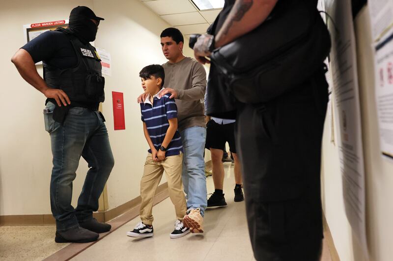 NEW YORK, NEW YORK - AUGUST 14: People walk past federal agents patrol as they the halls of immigration court at the Jacob K. Javitz Federal Building on August 14, 2025 in New York City. A federal judge ordered the Trump administration and Immigration and Customs Enforcement (ICE) to hold fewer people on the 10th floor holding cells in 26 Federal Plaza where detainees have complained of squalid and overcrowded conditions. The judge also gave an order to allow migrants to call to their lawyers and have access to proper medical and hygienic care. The ruling came after a lawsuit was filed by by legal organizations representing a Peruvian immigrant, Sergio Alberto Barco Mercado who was arrested by ICE and held at 26 Federal Plaza last week. (Photo by Michael M. Santiago/Getty Images)