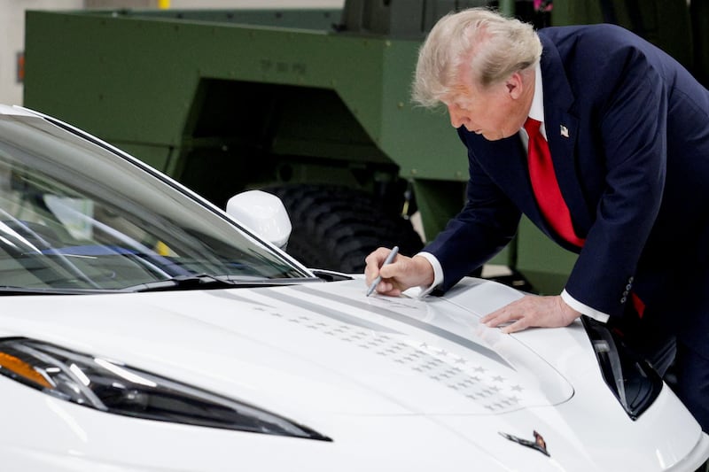 U.S. President Donald Trump signs his autograph on a Corvette as he participates in a tour at the General Motors Milford Proving Ground in Milford, Michigan, U.S., July 27, 2026. REUTERS/Evan Vucci     TPX IMAGES OF THE DAY