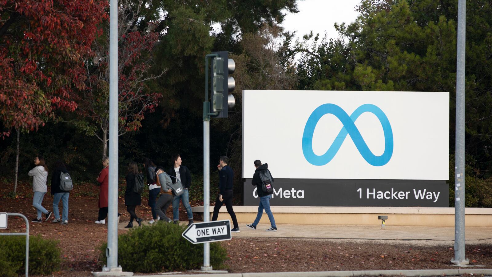 People leave after posing for photos in front of the logo of Facebook parent company Meta