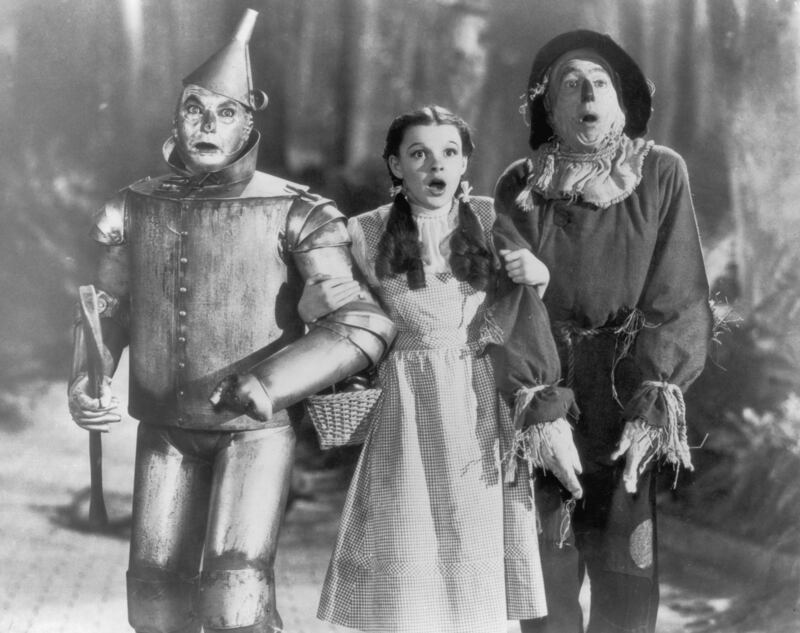 The Tin Man (Jack Haley), Dorothy (Judy Garland) and the Scarecrow (Ray Bolger) set off on their quest for fulfillment in the children's classic 'The Wizard of Oz', directed by Victor Fleming for MGM, 1939.