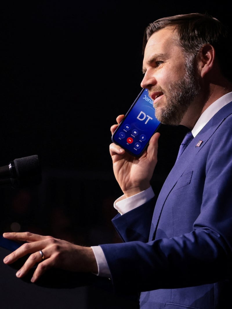 U.S. Vice President JD Vance holds a mobile phone while on a call with U.S. President Donald Trump while on stage during a Day of Friendship event with Hungarian Prime Minister Viktor Orban at MTK Sportpark in Budapest, Hungary, April 7, 2026. REUTERS/Jonathan Ernst/Pool